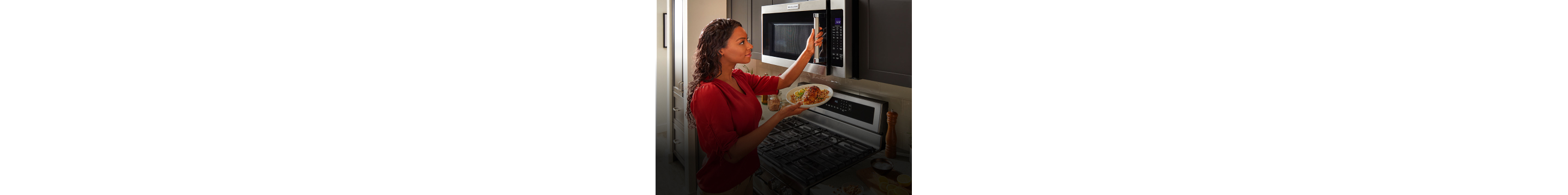 Woman holding food with her hand on microwave door.